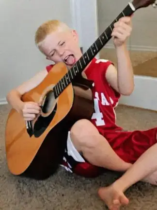 Ash Stu as a kid with his first guitar